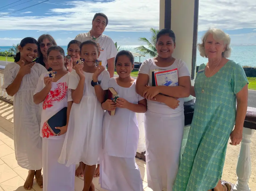 Smiling students and adults on a seaside veranda