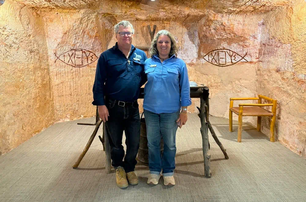 Two visitors in a recreated underground prison cell
