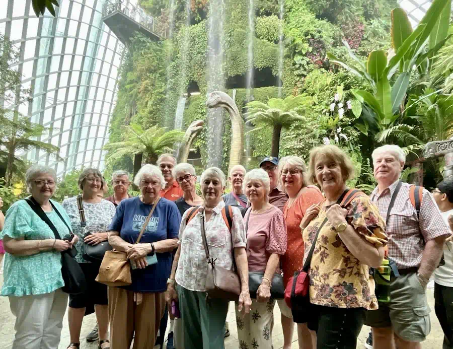 Seniors in lush indoor garden with dinosaurs