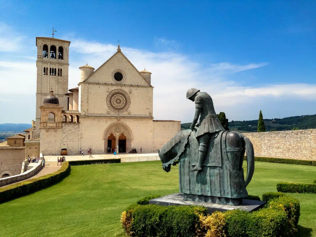 Statue before historic basilica under blue sky