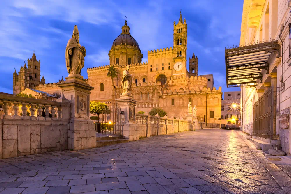 Palermo Cathedral illuminated at dusk with statues
