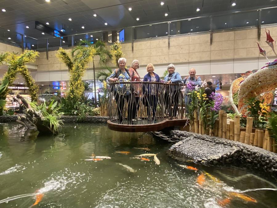 Group on bridge over indoor koi pond