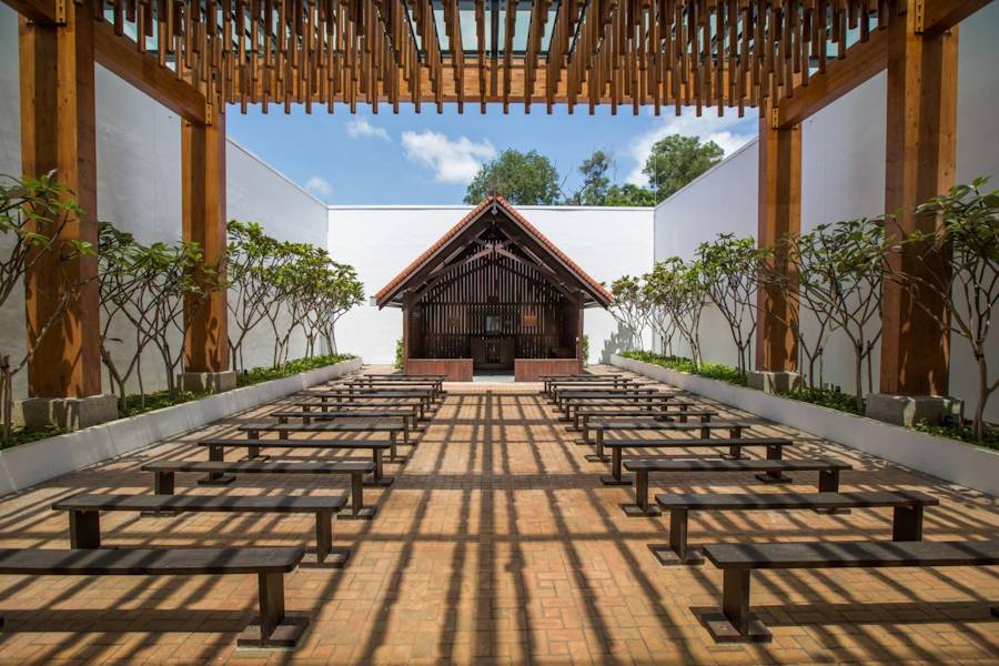 Open-air wooden chapel with rows of benches