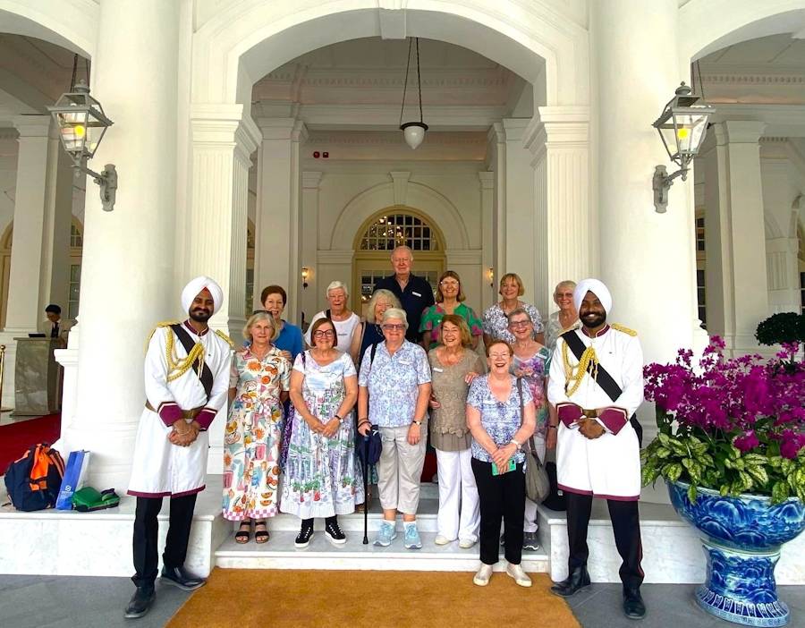 Group posing with ceremonial guards at grand building