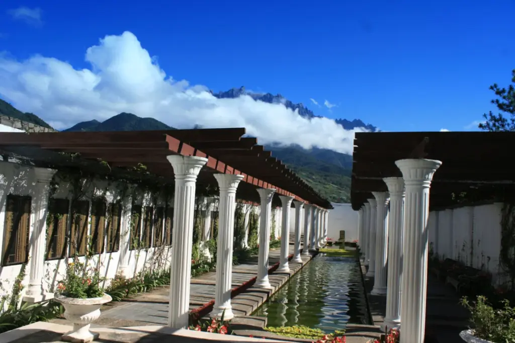 White colonnade and reflecting pool with mountains