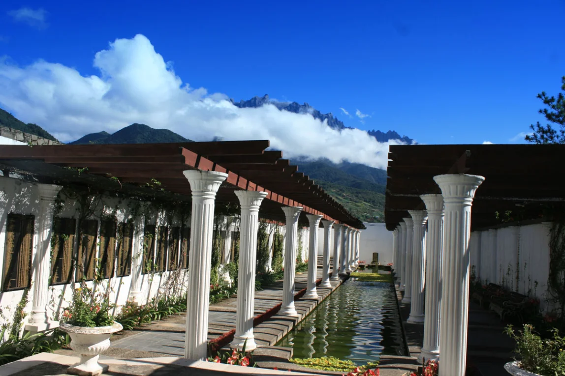 White colonnade and reflecting pool with mountains