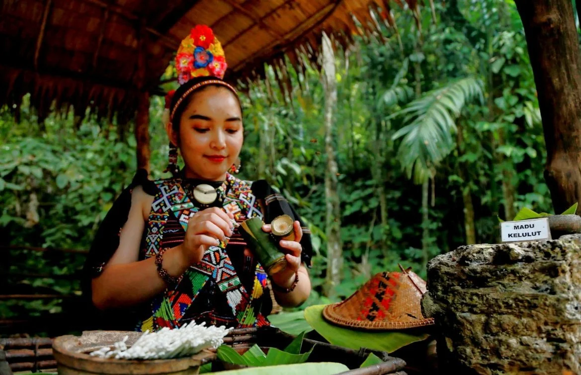 Woman in traditional dress preparing kelulut honey