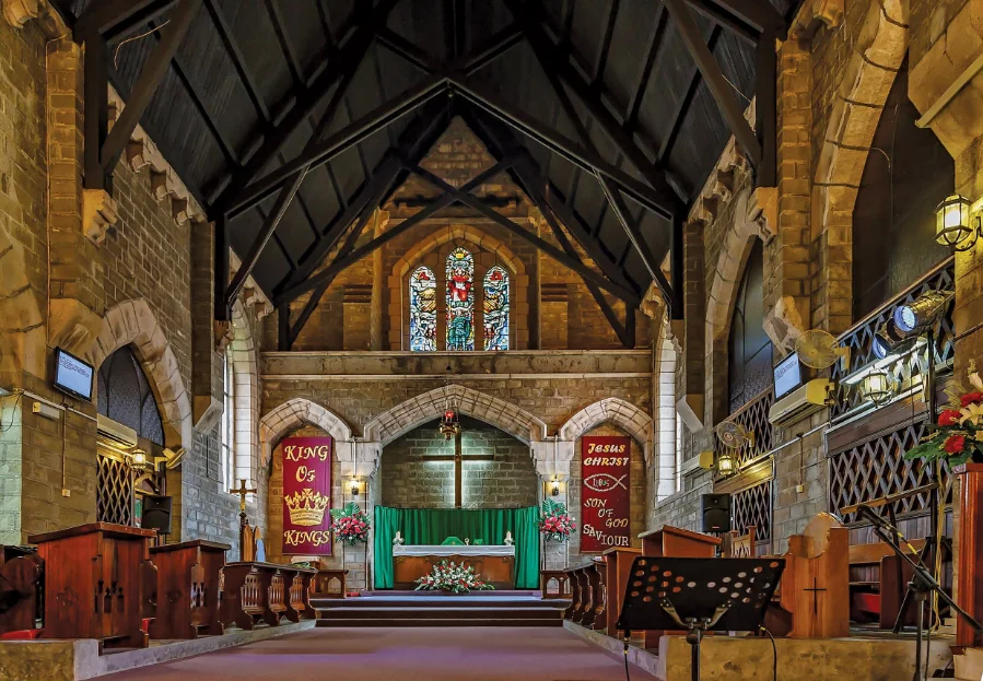 Stone church interior with altar and stained glass