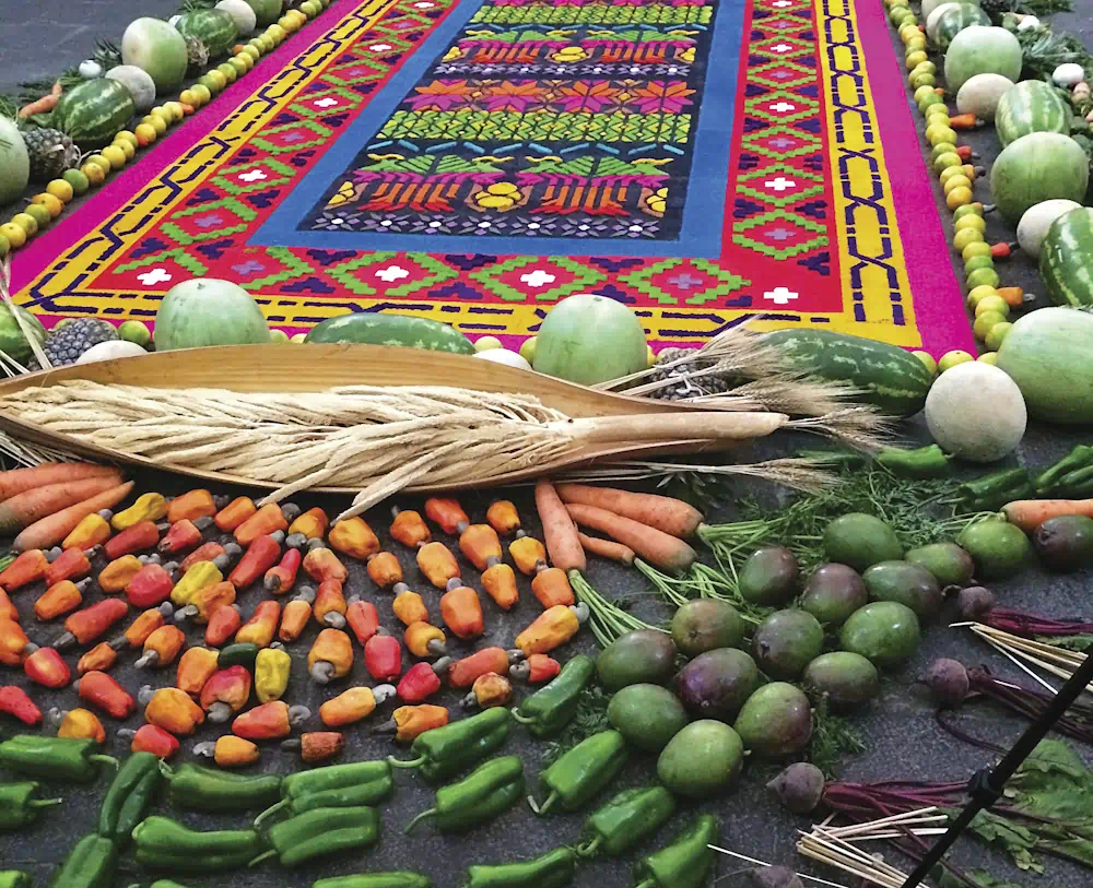 Colourful harvest display with fruits and patterned carpet