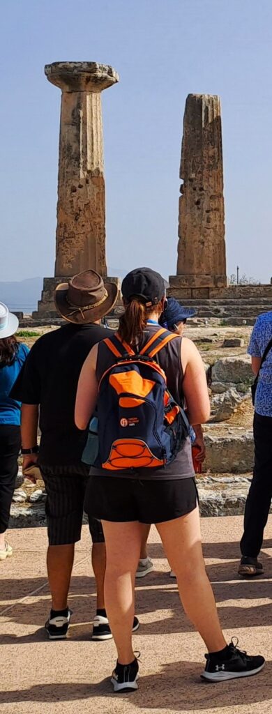 Tourists viewing ancient stone columns at ruins