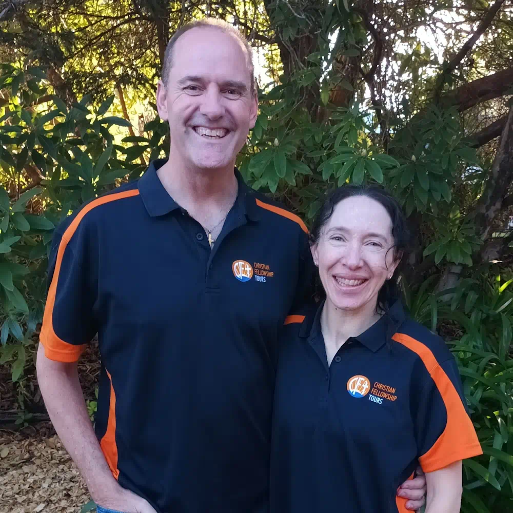 Smiling couple in matching tour company polos outdoors