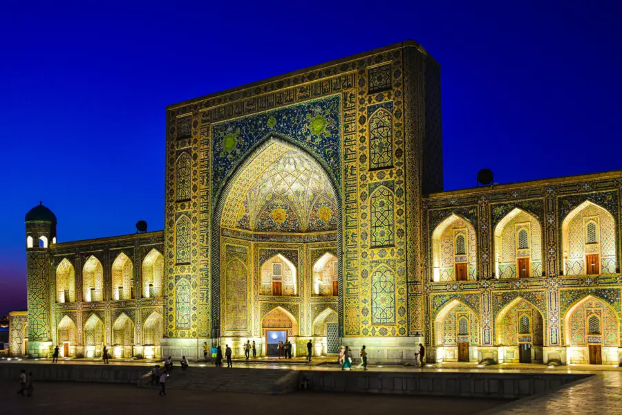 Illuminated tiled mosque entrance at dusk