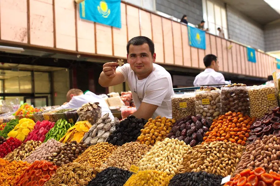Vendor selling colourful dried fruits and nuts at market