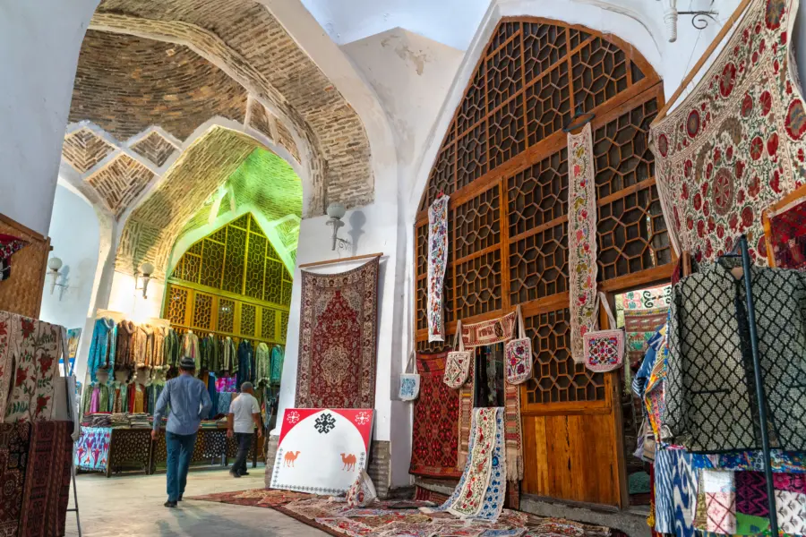 Colourful rugs displayed in a vaulted traditional bazaar
