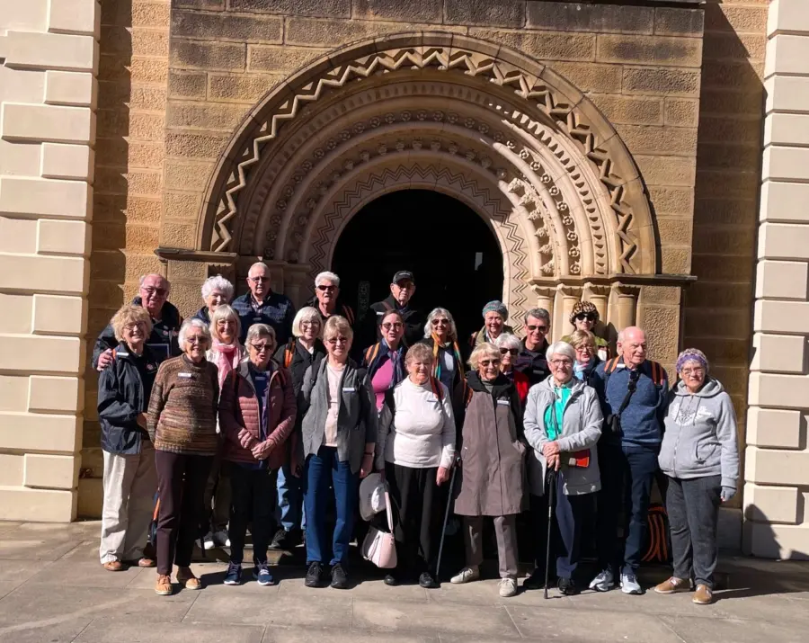 Group of tourists outside an ornate arched sandstone entrance