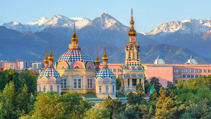 Colourful Ascension Cathedral beneath snow-capped mountains in Almaty